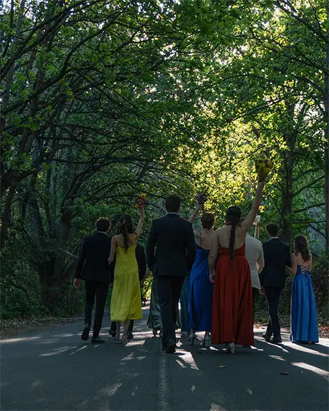 Men and women in formal attire walking down the road at the house dance predrinks photoshoot
