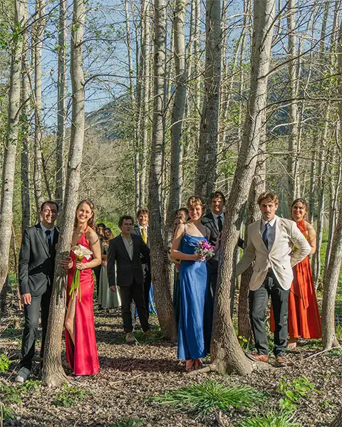 Couples posing inbetween trees at the house dance predrinks photoshoot