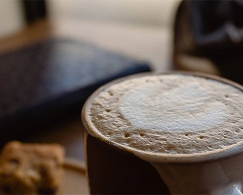 Foamy coffee cup on the table next the window at Spoon Bakery and Eatery