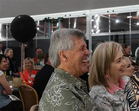 Middle-aged mad lauging heartily at Diverso's 20th birthday function