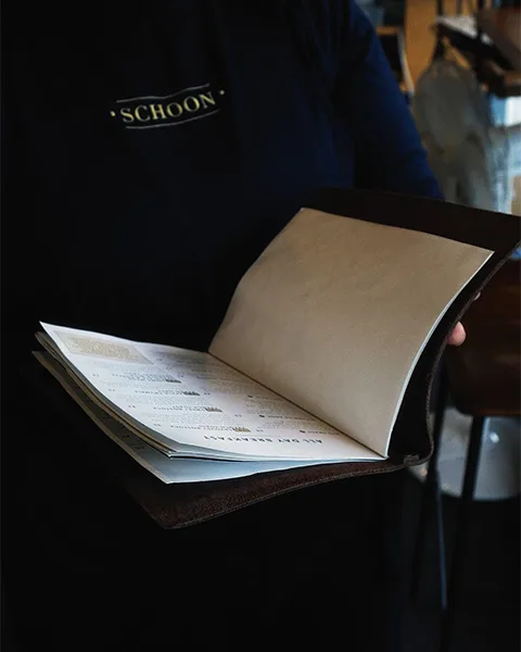 Waitress holding the menu at Schoon Coffee Shop